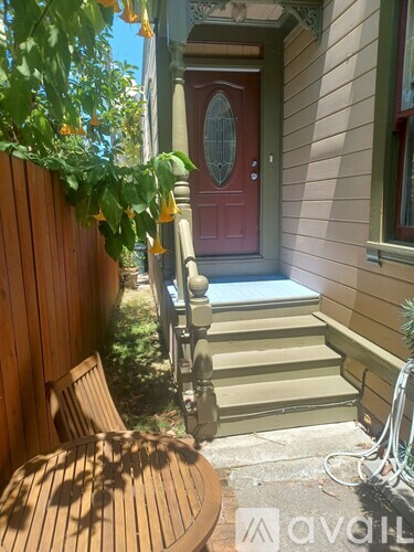A wooden chair is in front of a wooden fence.