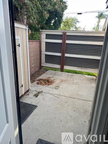 A backyard with a fence and a small patch of grass.