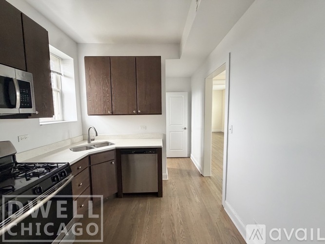 A kitchen with a stove, sink, and cabinets.