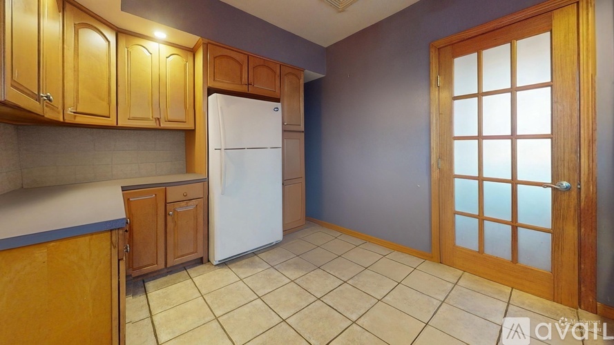A kitchen with wooden cabinets and a white refrigerator.