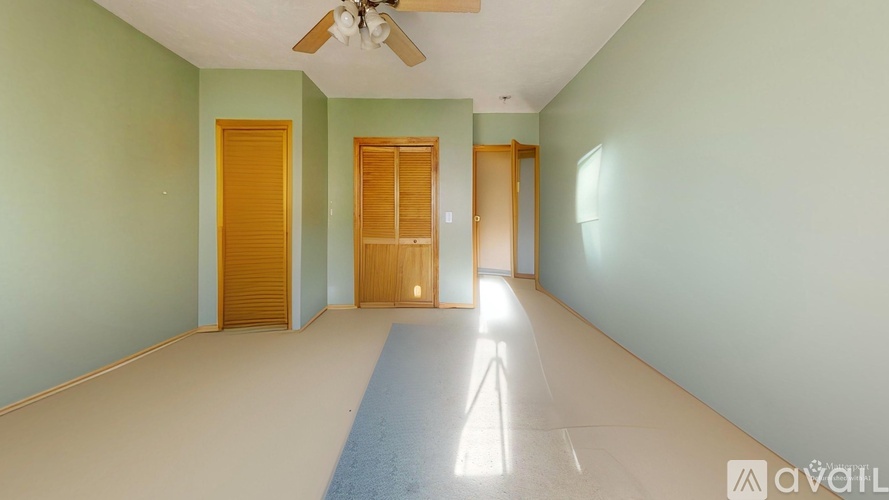A room with a blue stripe on the floor and a ceiling fan.