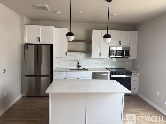 A kitchen with white cabinets and a stainless steel refrigerator.