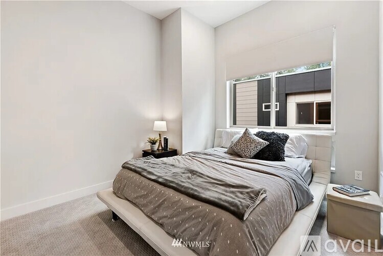 A bedroom with a large bed and a window.