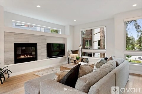 A modern living room with a grey sofa and a fireplace.