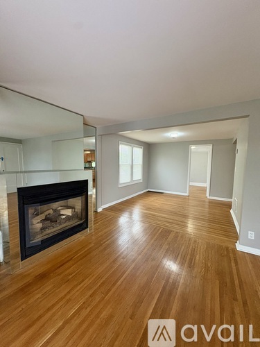 A room with a fireplace and wooden floors.