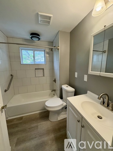 A bathroom with a white tub, toilet, and sink.