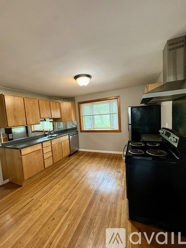 A kitchen with wooden cabinets and a black stove top oven.