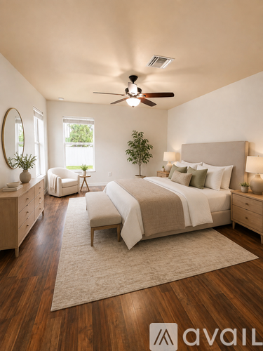 A bedroom with a large bed, a ceiling fan, and a rug on the floor.