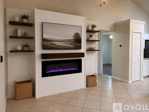 A modern living room with a fireplace and a painting on the wall.