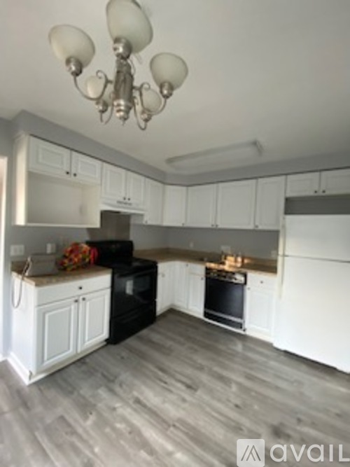 A kitchen with black appliances and white cabinets.