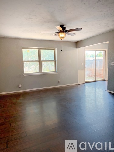 A room with a ceiling fan and a window.