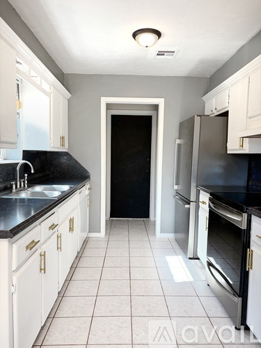 A kitchen with black countertops and white cabinets.