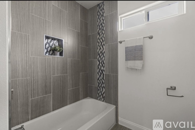 A bathroom with a tub and a window.