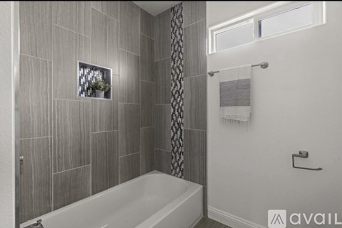 A bathroom with a tub and a window.