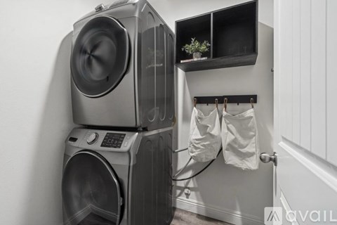 A washing machine and dryer stacked on top of each other in a laundry room.
