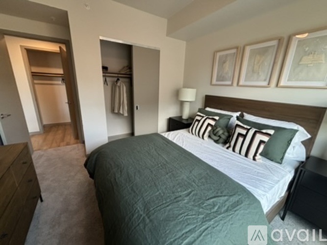 A bedroom with a large bed and a wooden dresser.