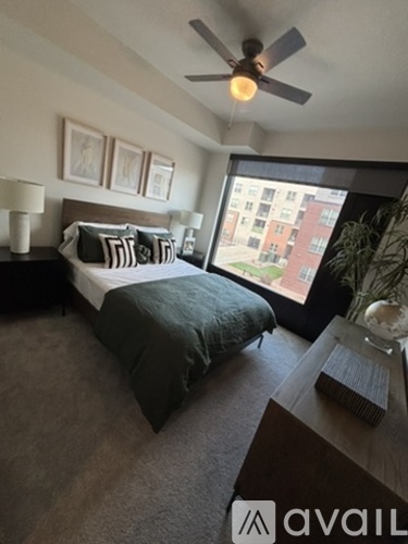 A bedroom with a bed, nightstand, and window.