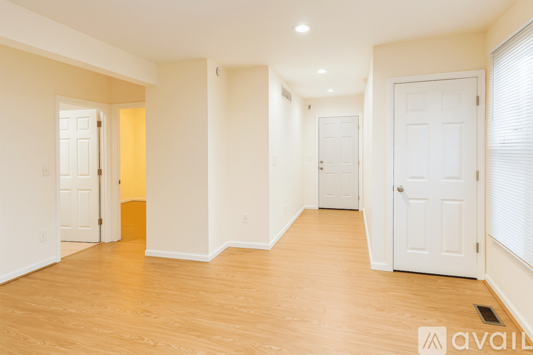A spacious room with wooden floors and white walls.