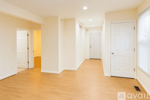 A spacious room with wooden floors and white walls.