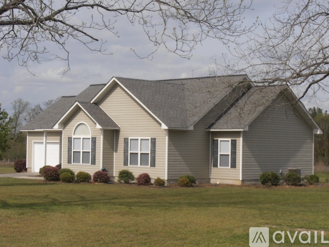 A house with a grey roof and a white door is available for purchase.