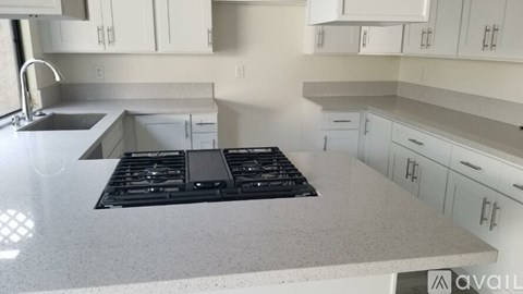 A kitchen with a black stove top oven sitting on a countertop.
