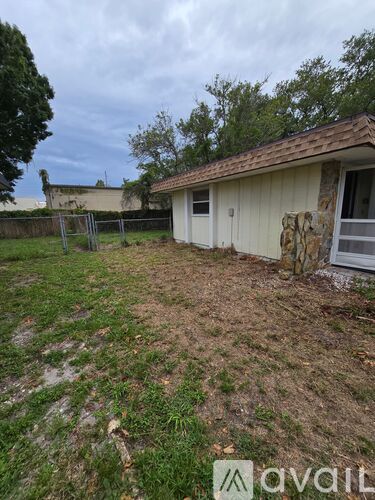 A backyard with a shed and a fence.