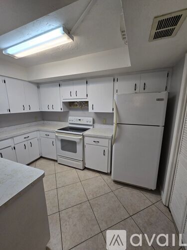 A kitchen with white cabinets and appliances.