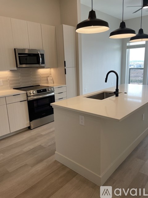 A kitchen with a white countertop and a black microwave above it.