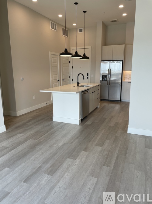 A kitchen with a white island and wooden flooring.