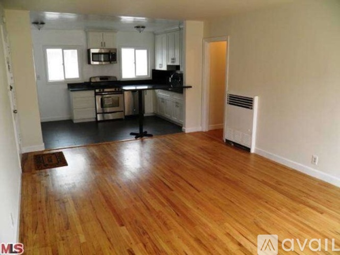 A kitchen with wooden floors and white walls.