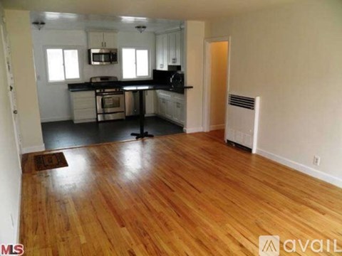 A kitchen with wooden floors and white walls.
