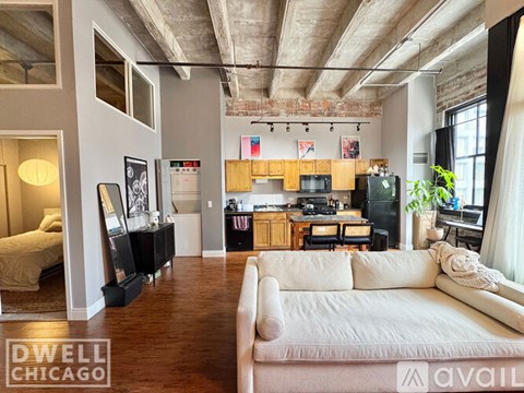A living room with a white couch and a kitchen area in the background.