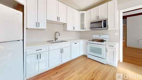 A kitchen with white cabinets and appliances.