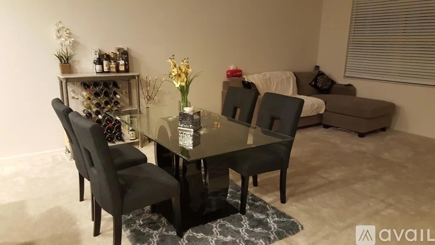 A modern dining room with a glass table and chairs.