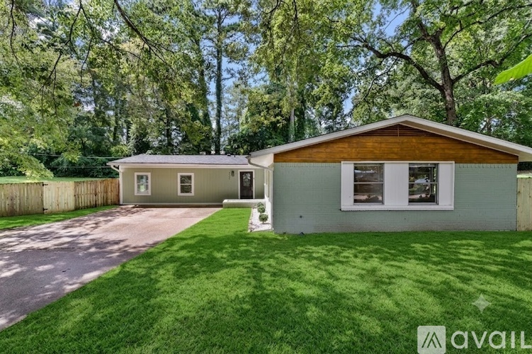 A house with a green lawn and trees in the background.