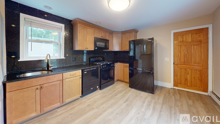 A kitchen with wooden cabinets and black appliances.