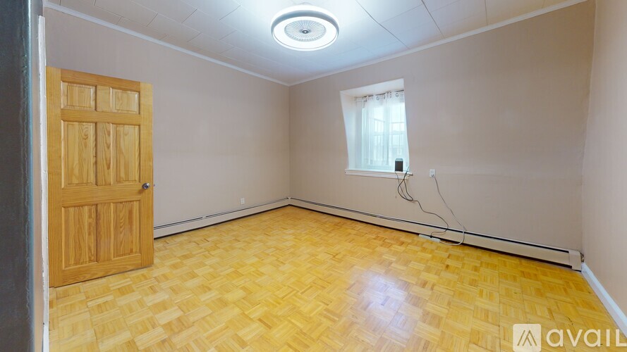A room with wooden flooring and a door.
