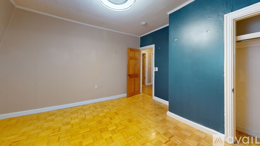A room with a wooden floor and a ceiling fan.