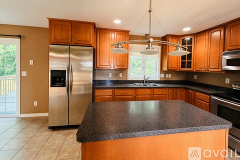 A kitchen with wooden cabinets and a granite countertop.