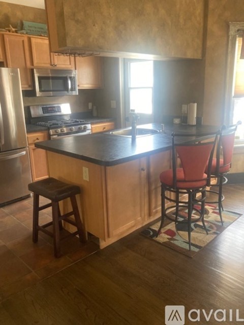 A kitchen with a black countertop and wooden cabinets.