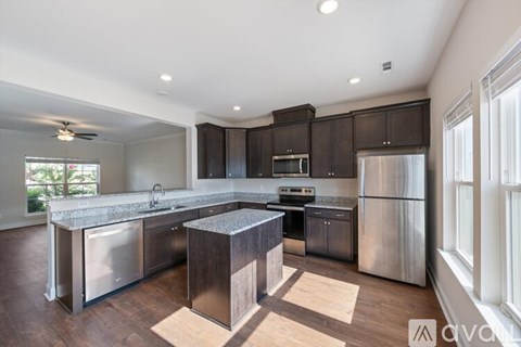 A modern kitchen with stainless steel appliances and wooden cabinets.
