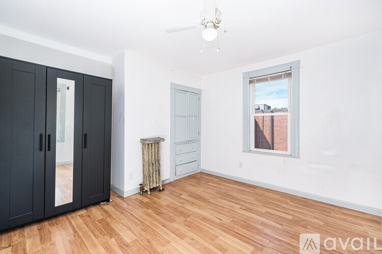 A room with a window and a wooden floor.