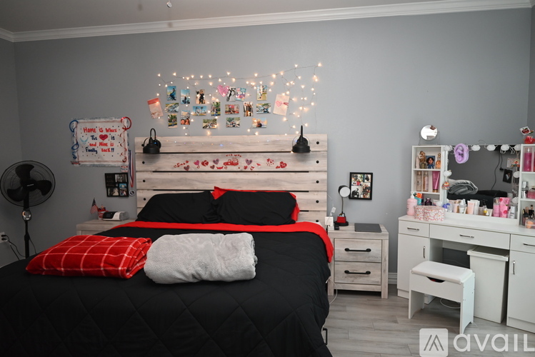 A bedroom with a black bedspread and a white bed frame.