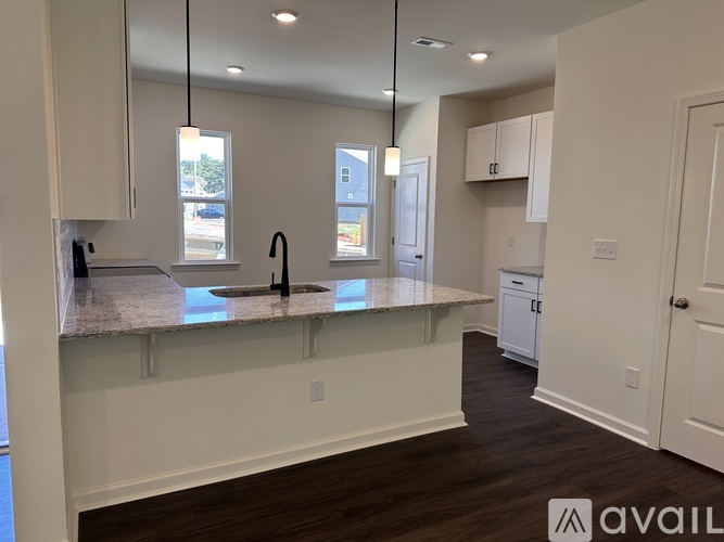 A kitchen with a granite countertop and white cabinets.