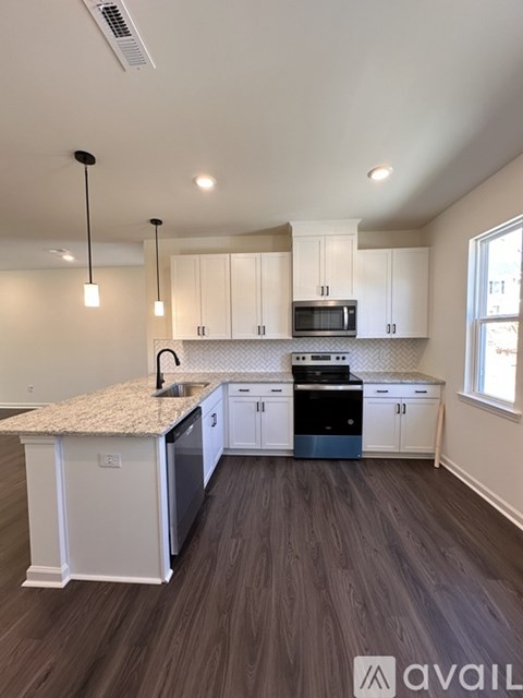 A kitchen with white cabinets and a granite countertop.