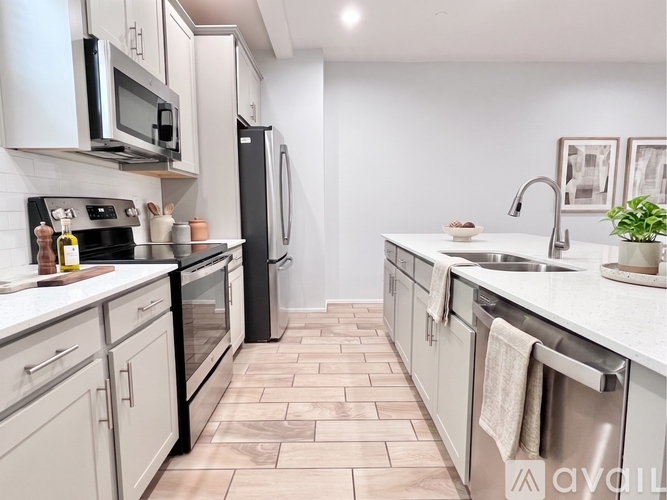 A kitchen with a black refrigerator and white cabinets.