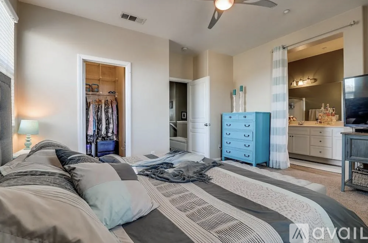 A bedroom with a large bed and a blue dresser.