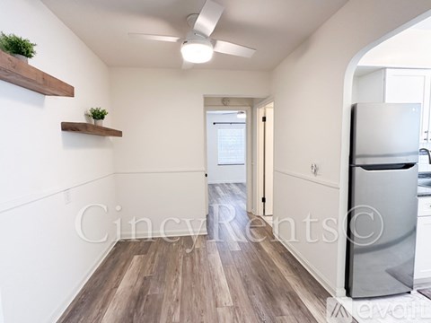 A kitchen with a refrigerator and a ceiling fan.