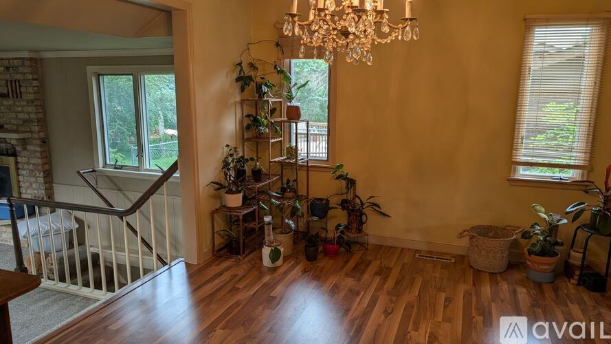 A living room with a chandelier, a fireplace, and a staircase.