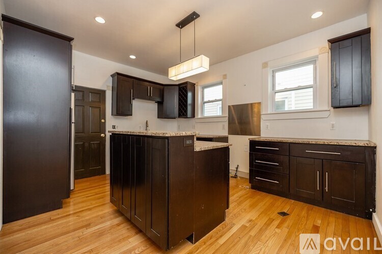 A kitchen with dark wood cabinets and a center island.